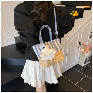 Detail of striped canvas beach bag featuring a cute white lamb doll and woven texture base