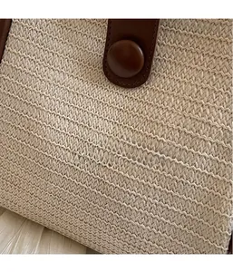 Close-up of the woven texture and premium brown leather details on the tote bag