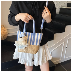 Detail of striped canvas beach tote with woven base and cute plush bear accessory