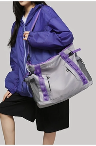 Waterproof travel bag with purple straps and grey nylon fabric shown on a model