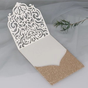 Vue macro d'une invitation de mariage laser avec motifs crème et pochette dorée pailletée