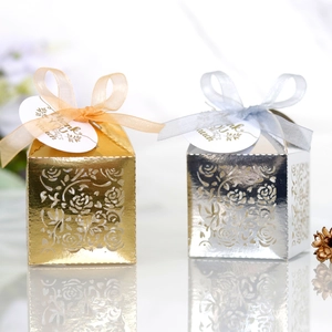 Detail of laser-cut rose patterns on pink wedding favor boxes with Thank You tags