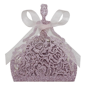 Close-up of laser-cut flower patterns on pink glitter favor box with organza ribbon