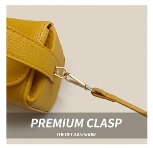 Detail shot of yellow pebble grain leather texture with gold metal hook attachment