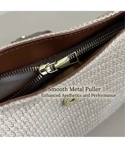 Detail of light gold metal zipper and brown lining on woven straw tote bag texture