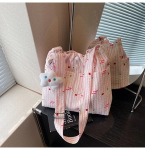 Détail de la texture du tissu en nylon rayé rose avec imprimés cerise et oursons