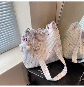Détail du sac cabas en nylon à rayures bleues avec imprimé floral et cordon de serrage
