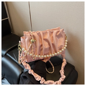 Detail of pink pleated cloud bag featuring glossy PU leather and elegant pearl chain