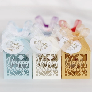 Detail of laser-cut Happy Birthday gift boxes with silk ribbons and thank you tags