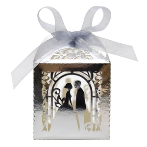 Detail of silver laser-cut wedding favor box with bride groom silhouette and ribbon