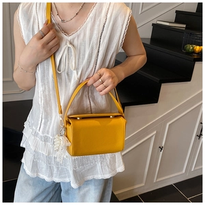 Detail of yellow box bag with lychee texture and pearl lace decorative pendant