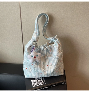 Détail du sac seersucker à rayures bleu clair avec cordon et breloque étoile