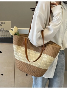 Minimalist straw woven tote bag with brown straps and striped two-tone design shown in lifestyle set