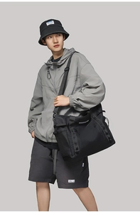 Close-up of black waterproof travel bag with side mesh pocket and nylon webbing details