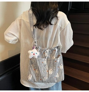 Détail du sac en nylon rayé avec imprimé fleuri, cordon et pendentif en étoile