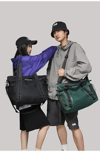 Detail of waterproof nylon travel bags in black and dark green with mesh side pockets