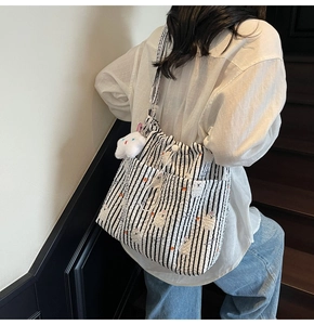 Détail du sac cabas en nylon rayé avec texture seersucker et breloque nuage doux