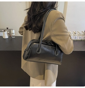 Detail of vintage black pillow bag with white contrast stitching and long shoulder straps