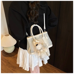Détail du sac seau blanc avec pendentif chiot en peluche et bandoulière amovible