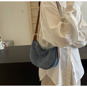 Denim blue moon-shaped hobo bag with silver metallic studs and brown leather strap