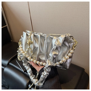 Detailed view of silver pleated clutch featuring faux pearl chain and metallic texture