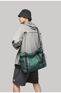 Side view of dark green large travel tote bag with MINGDAILANDI text on shoulder