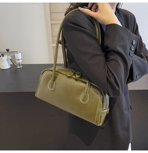Detail view of olive green boston bag with white contrast stitching and long double handles