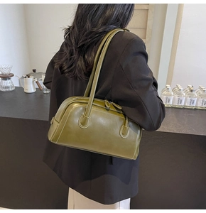 Detail of dark green vintage Boston bag with white stitching and long shoulder straps