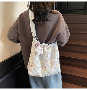 Détail du sac matelassé à rayures bleues avec cordon et pendentif étoile en peluche