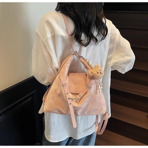Pink tote bag detail with adjustable shoulder strap and cute brown plush bear pendant