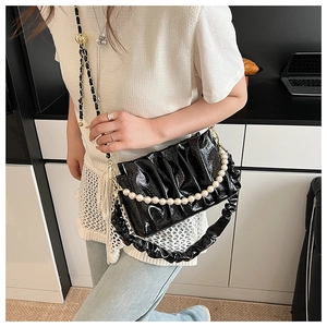 Close-up of pleated black PU bag featuring elegant pearl chain and soft texture