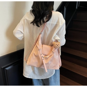 Pink fashion shoulder bag detail with adjustable strap and cute brown teddy bear charm