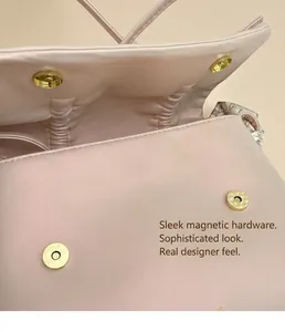 Détail du sac à nœud rose montrant le fermoir magnétique doré et la doublure plissée