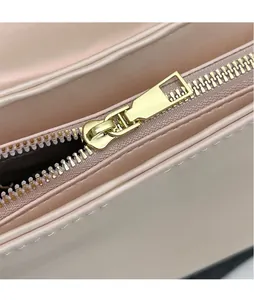 Détail d'un sac en cuir rose avec fermeture éclair en métal doré et couture fine