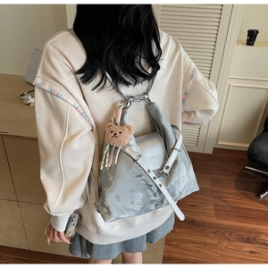 Silver metallic backpack with chain link detail and cute brown teddy bear charm