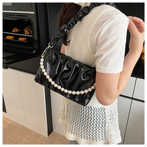 Détail du sac nuage plissé en cuir verni noir avec chaîne décorative en perles