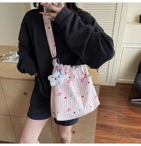 Détail du sac à bandoulière rayé en nylon avec motifs cerise ours et breloque étoile