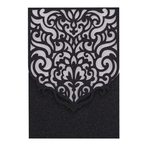 Détail d'une carte d'invitation noire découpée au laser avec paillettes et fleurs