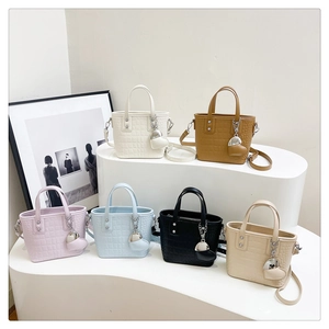 Detail of mini tote bags in six colors with crocodile pattern and heart charms