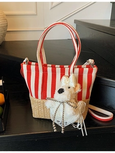 Striped fabric and woven straw tote bag with a cute plush dog charm accessory