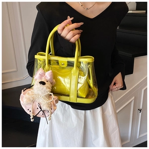 Détail du sac seau transparent jaune en PVC avec breloque ours en peluche et pochette cuir
