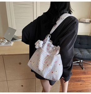 Sac bandoulière en nylon à rayures bleues avec pendentif nuage dans un décor quotidien