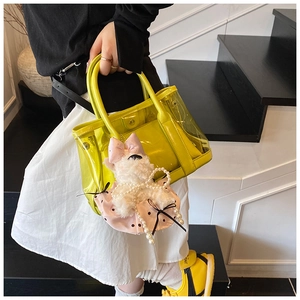 Vue détaillée d'un sac seau en PVC jaune transparent avec pendentif chien en peluche