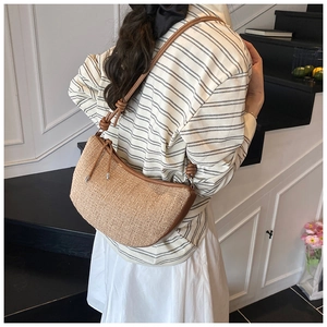 Detail of woven crescent hobo bag featuring brown leather knotted strap and texture