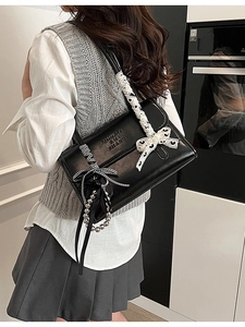 Fashionable black leather shoulder bag with lace bow handle and metallic charms for women