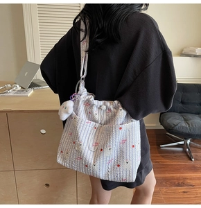 Détail du sac cabas rayé bleu avec motifs d'ours et pendentif en peluche lapin mignon