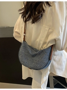 Denim hobo shoulder bag with silver studs and brown leather strap on model