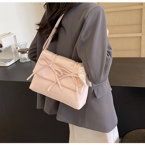 Vue détaillée du sac à bandoulière rose à nœud avec cuir plissé et foulard à cœurs