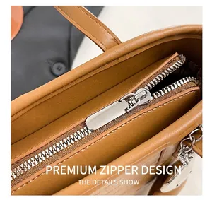 Detail of silver metal zipper and brown leather texture on stylish bucket bag