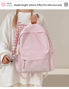 Close-up of pink nylon backpack featuring a brand logo and silver mechanical bear charm